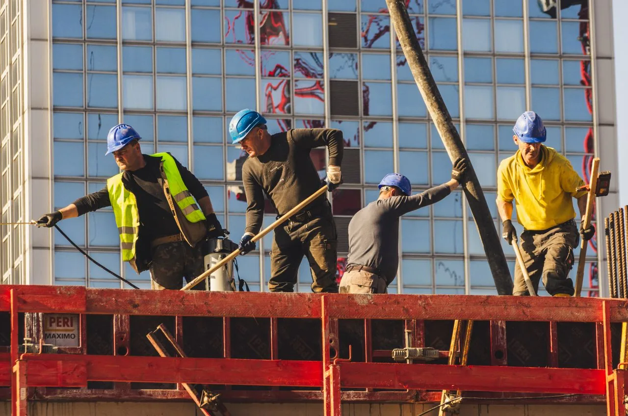 Equipe de operários trabalhando na fôrma da laje em obra predial, mão de obra CLT da Shark Construtora em Curitiba